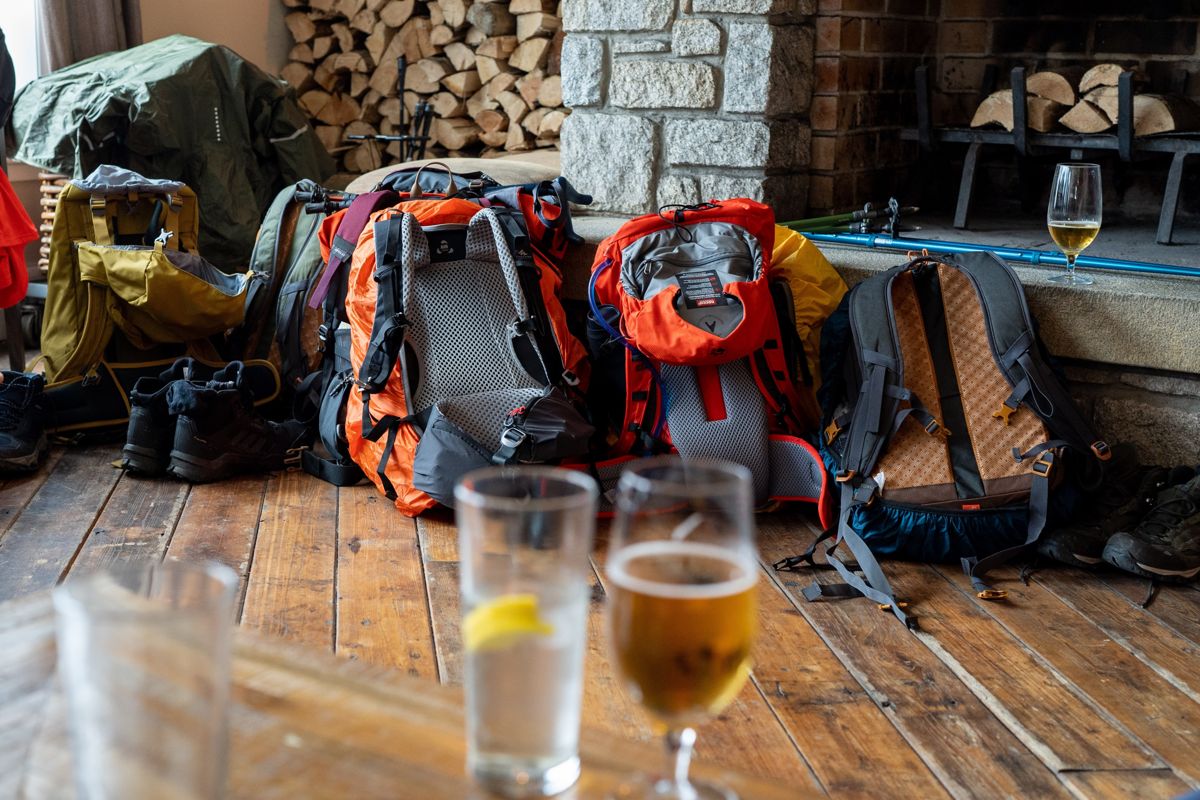 Rugzakken bij de open haard in een Schotse pub, met een glas bier op tafel